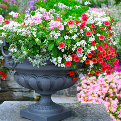 Beautiful flower arrangement in a metal vase in a summer park.