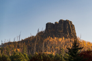 Mount Raven Stone (Havraní skála) near Jetrichovice (Czech Republic) in golden morning light. against blue sky