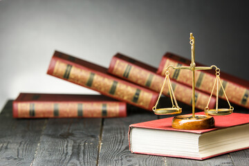 Law concept - Open law book with a wooden judges gavel on table in a courtroom or law enforcement...