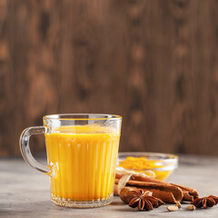 Golden Cinnamon Lemon Turmeric Tea. Trendy hot Healthy drink with turmeric roots and spices. Wooden background
