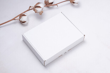 White cardboard box decorated with cotton flower branch
