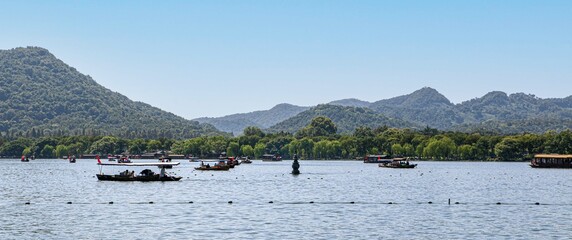 Hangzhou West Lake Scenery, one of the 'three pools mirroring the moon', tour boats and rowing boats float by one of the three gourd shaped stone pagodas