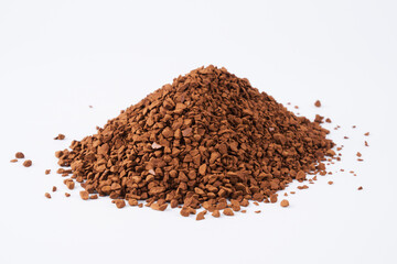 Freeze-dried instant coffee on white background close-up. Heap of powdered brown coffee product scattered on the table