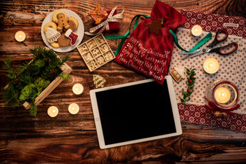 Flat lay decoration Christmas decoration, gifts, cookies and tablet on a wooden table