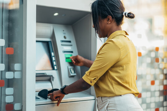 African american woman using an atm machine and a credit card