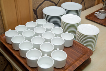 Thermos with hot water and cups for afternoon tea on the wood table in luxury five star hotel. Hot beverages catering. Set of coffee break in the hotel during conference meeting, with tea and coffee