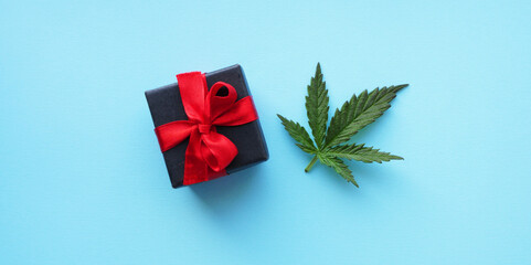 Flat lay gift box with cannabis leaf. CBD product present banner. Marijuana Christmas celebration 