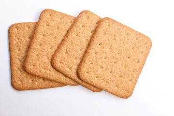 four square shaped biscuit stacked on white background, top view, selective focus