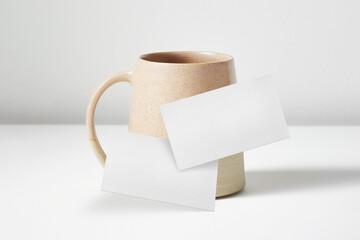 Clean minimal business card mockup floating in front of a tea cup