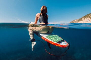 Sexy surf girl on surfboard in ocean, split view - obrazy, fototapety, plakaty