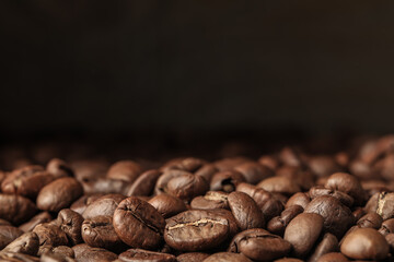 Many roasted coffee beans on dark background, closeup