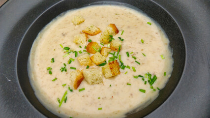 Detail view of delicious mushroom soup with croutons and chives.