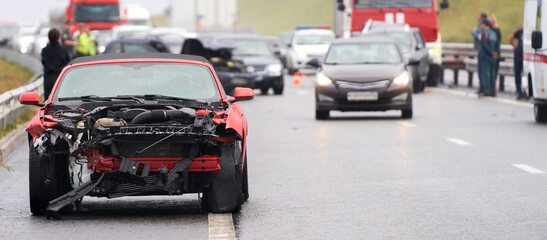 Congestion on the road due to the collision of cars. In the foreground is a red car with a broken...