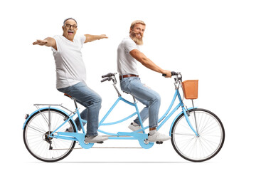 Young and mature man riding on a tandem bicycle with arms wide open