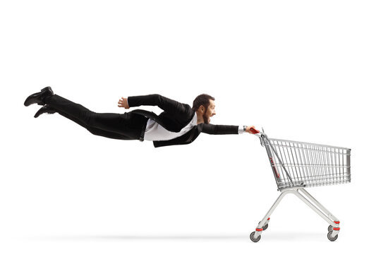 Full length shot of a businessman flying and holding an empty shopping cart