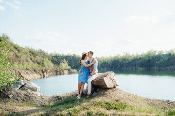 a young couple a guy and a girl are walking near a mountain lake surrounded