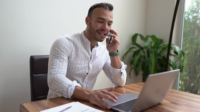 Portrait young mexican attractive businessman working at modern home office with computer laptop