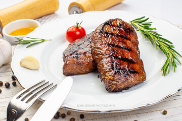Piece of roast beef with spices served on white plate