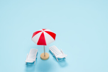Travel concept. Sun lounger, red umbrella on a blue background.
