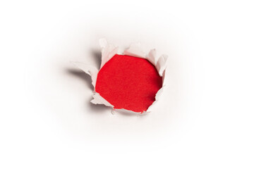 A hole in a white paper on a red background.