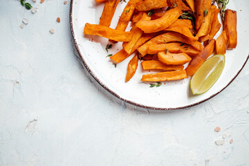Sweet potato fries with lime on white background. Food recipe background. Close up