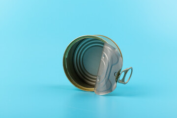 opened clean tin can with pull tab ring, bended lid and empty - isolated on blue