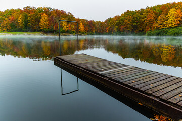 Fall Color and Fishing Pier Reflectiing on Boley Lake, Babcock State Park, West Virginia, USA