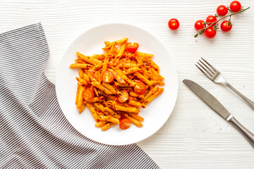Plate of pasta penne with tomato sauce and herbs