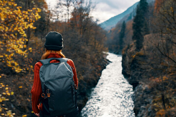 woman tourist backpack river mountains autumn