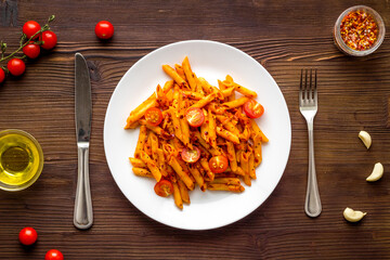 Plate of italian pasta penne with tomato sauce and herbs