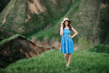 young girl in a straw hat with large brim on mountain slopes
