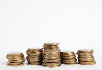 Many Euro coins stacked on white background