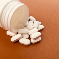 White pill (medicine) in a white bottle.