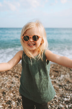 Child girl taking selfie on sea beach baby happy smiling wearing sunglasses 3 years old kid traveling outdoor family fun vacations