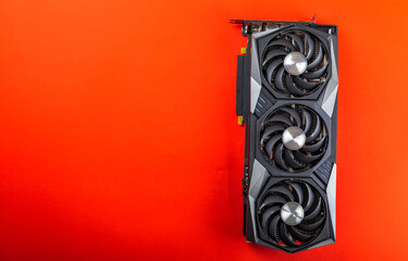 Gaming video card on a red background for video games and cryptocurrency mining. Computer part. GPU card. copy space