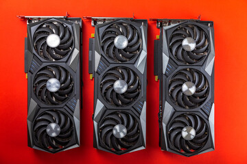 Gaming video card on a red background for video games and cryptocurrency mining. Computer part. GPU card.