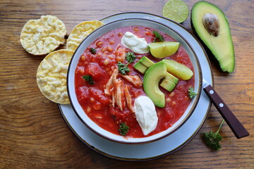 Chicken tortilla chili soup with beans, avocado, lime, . Mexican traditional dish