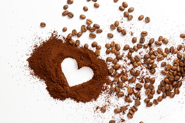 grãos de café derramados em torno de um monte de café em pó com formato de coração no meio em...