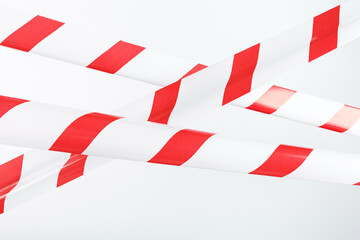Red and white striped fencing tape on a white background.