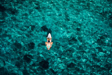 Aerial view with surfer woman on surfboard