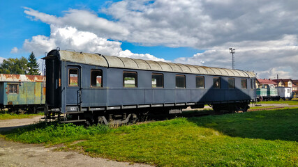 Fototapeta premium Abandoned unused railway carriage outside of the train station during beautiful weather.