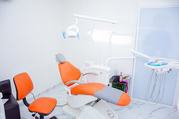 dentist's workplace with an orange stretcher, chair and tools