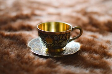 Golden cup and saucer on textile
