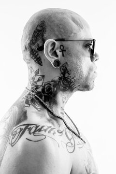 Grayscale photo of tattooed man wearing sunglasses