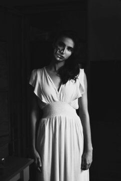 Grayscale portrait of woman in long dress with face paint