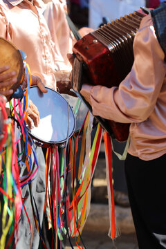Group pf men in colorful clothes playing tambourine and music as part of religious festival of the state of Minas Gerais in Brazil