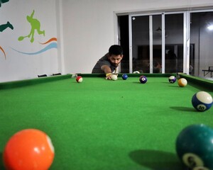 Man in black shirt playing billiard