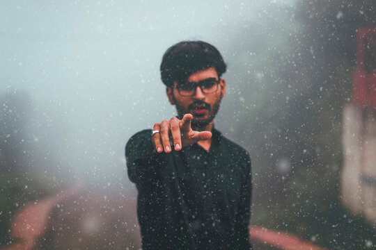 Man in dark shirt pointing his finer