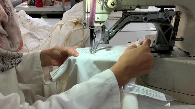 Process of making blue jeans pants in video on sewing machine in an industrial clothing factory. Textile concept. Video