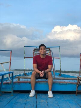 Man sitting on bench in blue boat